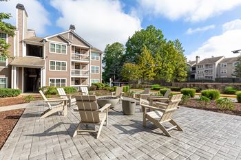 A patio with chairs and a table in front of a building.